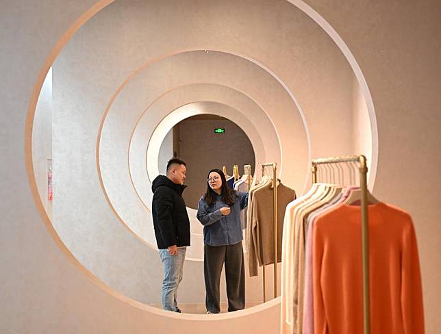 A staff member introduces cashmere sweaters to a customer at the exhibition hall of a cashmere products manufacturer in Qinghe County, Xingtai City, north China's Hebei Province, Jan. 18, 2025. (Xinhua/Mu Yu)