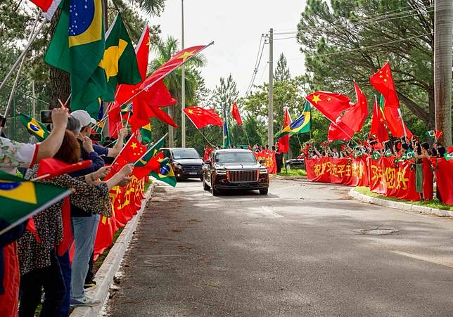 Representatives of overseas Chinese, Chinese institutions and students wave the national flags of China and Brazil on both sides of the road, congratulating Chinese President Xi Jinping on the complete success of his visit, while Xi's motorcade is on its way to the airport in Brasilia, Brazil, Nov. 21, 2024. Xi left Brasilia on Thursday after attending the 19th G20 Leaders' Summit and paying a state visit to Brazil. (Xinhua/Wang Tiancong)