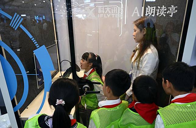 Children try an AI-powered reading device during the 6th World Voice Expo in Hefei, east China's Anhui Province, Oct. 24, 2023. (Xinhua/Zhou Mu)