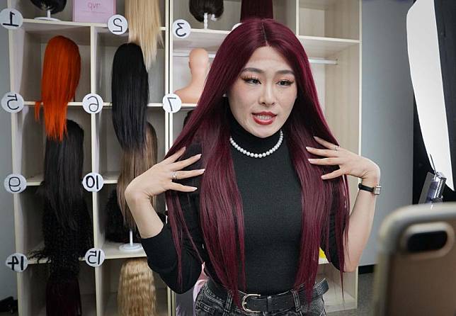 A worker of Henan Henan Rebecca Hair Products Co., Ltd introduces a wig through livestreaming in Xuchang City, central China's Henan Province, March 16, 2023. (Xinhua/Li An)