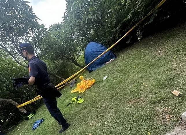 台中市文心公園昨日有民眾發現一具男屍，警方獲報到場使用帷幕覆蓋，並封鎖現場採證。 （記者陳金龍翻攝）