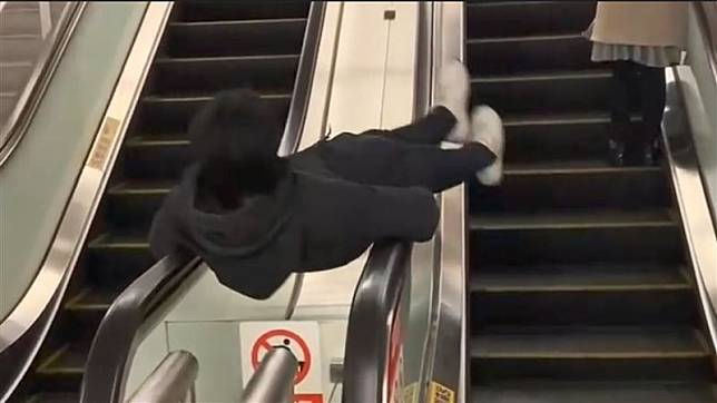 屁孩於捷運站電扶梯扶手間，以「旋轉、上往下滑」等危險動作博取眼球，引發爭議。（翻攝自網路）