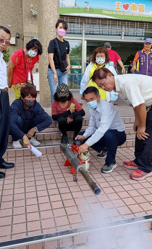 區長和里長體驗國軍在用的大型噴槍。（記者陳俊文攝）