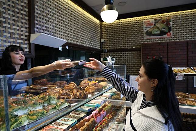 A customer buys Dubai chocolate at a shop in Ankara, Türkiye, Jan. 8, 2025. (Mustafa Kaya/Handout via Xinhua)