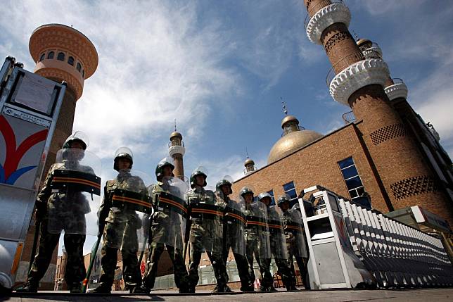 Chinese paramilitary police in riot gear stand guard at the entrance to a large mosque in the centre of Urumqi, in China’s Xinjiang Autonomous Region, in July 2009. Photo: Reuters