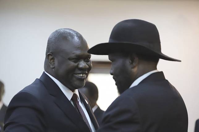 Rebel leader Riek Machar (left) and President Salva Kiir greet each other after the swearing-in ceremony at the State House in Juba on Saturday. Photo: AP