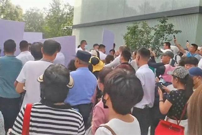 中國近期傳出多起民眾抗爭事件，圖為本月4日投資人在北京中植集團總部抗議，遭白衣人強行阻攔。（取自@whyyoutouzhele）