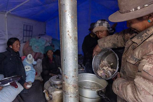 Earthquake-affected residents cook dinner in a tent at a village in Xigaze, southwest China's Xizang Autonomous Region, Jan. 7, 2025. (Xinhua/Jiang Fan)