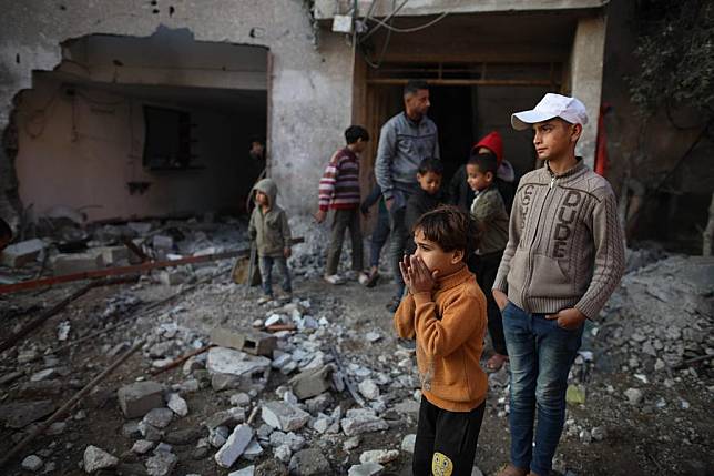 People are seen at a damaged building after an Israeli airstrike in the al-Nuseirat refugee camp, central Gaza Strip, on Dec. 12, 2024. (Photo by Marwan Dawood/Xinhua)