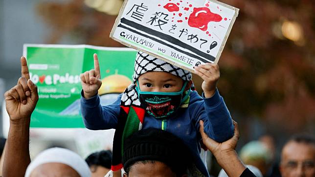 以色列駐日本東京大使館附近，一名男孩舉著寫有「停止屠殺」的標語牌。路透社