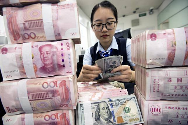 A clerk counts banknotes at a bank outlet in Hai'an, Jiangsu province, in China. Photo: EPA-EFE