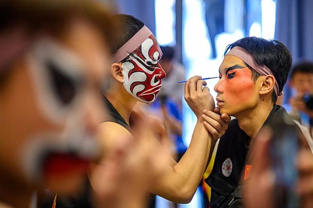 Members of a Yingge team from China put on makeup for performance in Johor, Malaysia, Feb. 18, 2025. (Photo by Chong Voon Chung/Xinhua)