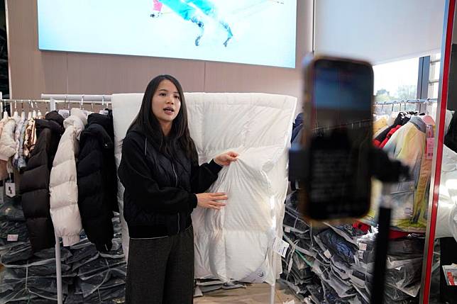 A staff member introduces a duvet with feather and down via live-streaming at an industrial park in Qiaoxu Township, Guigang City, south China's Guangxi Zhuang Autonomous Region, Nov. 26, 2024. (Xinhua/Yang Chi)