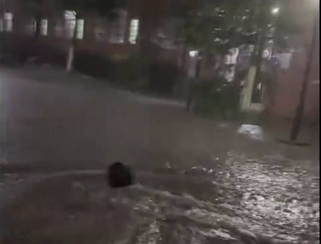 瞬時暴雨造成貴陽市多地淹水，有市民在積水中游泳。 圖：翻攝自新京報