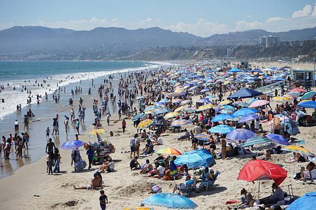 People cool off at Santa Monica beach in Los Angeles, California, the United States, June 23, 2024. (Photo by Zeng Hui/Xinhua)