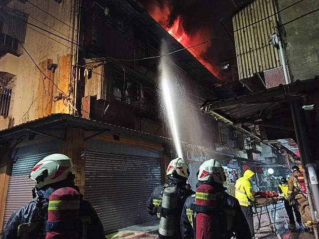 消防隊員到場已看見火舌竄出，緊急以高壓水線灌救。（基市消防局提供）