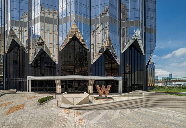 澳門新濠影滙W酒店建築外觀由Zaha Hadid Architects打造，另可見金色系的「W」標誌性logo至於正門口。