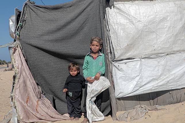 Displaced children stand by a tent in the northwest of Khan Younis, southern Gaza Strip, on Nov. 12, 2024. (Photo by Rizek Abdeljawad/Xinhua)