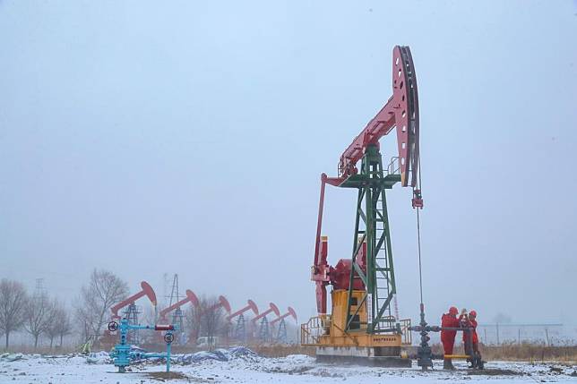 Workers perform their tasks at an oil platform on a snowy day in Daqing Oilfield in Daqing, northeast China's Heilongjiang Province, Nov. 25, 2024. (Photo by Ma Ke/Xinhua)