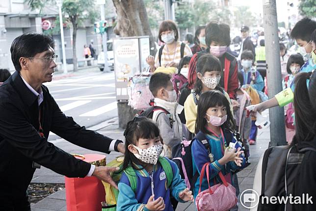 因應武漢肺炎疫情，各校繃緊神經加強防疫。圖為北市新和國小校長張伯謙引導小朋友們進校園量測額溫。   圖：張良一/攝（資料照片）