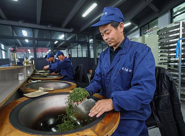 Workers process tea leaves at a workshop of Anding Village in Lishan Township in Hangzhou, east China's Zhejiang Province, April 8, 2024. (Xinhua/Xu Yu)