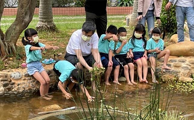 黑松教育基金會董事長張斌堂，與霄裡國小師生一同體驗埤塘生態課程。（圖片來源：黑松教育基金會提供）