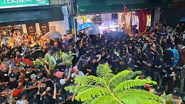大甲媽祖鑾轎回鑾，24日晚間準備前往天后宮駐駕前，爆發一群黑衣人試圖搶扶娘傘，警方強制推開人群，化解衝突。Threads網友授權