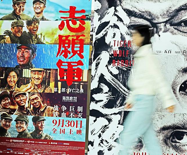 A woman walks past film posters at a cinema in Tancheng County, east China's Shandong Province, Oct. 7, 2024. (Photo by Zhang Chunlei/Xinhua)