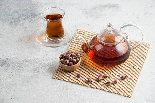 glass-cup-tea-with-dried-roses-teapot_114579-38615