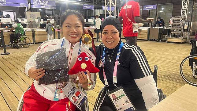 China's powerlifter Tan Yujiao (L) poses for a photo after receiving a gift from Egypt's Fatma Omar. (Photo courtesy of Tan Yujiao)