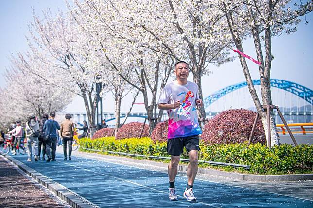 A citizen runs on a greenway for exercise in Binjiang District in Hangzhou, east China's Zhejiang Province, March 29, 2024. (Xinhua/Jiang Han)