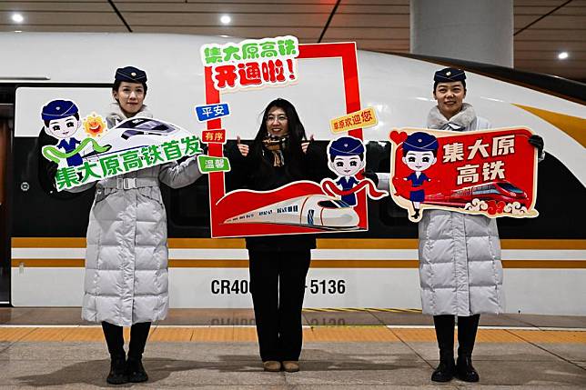 A passenger &copy; poses for photos at Hohhot East Railway Station in Hohhot, north China's Inner Mongolia Autonomous Region, Dec. 31, 2024. (Xinhua/Li Zhipeng)