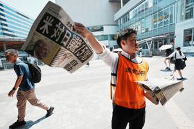 日本《讀賣新聞》社論罕見批評台灣時政。圖為7月23日美國總統川普宣布對日關稅後，《讀賣新聞》在街頭發送號外。（美聯社）
