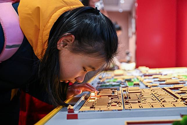 A student from the Beijing School for the Blind touches a sand table model of the Palace Museum at Sensory Experience Gallery of the Palace Museum in Beijing, capital of China, Dec. 1, 2024. (Xinhua/Li Xin)