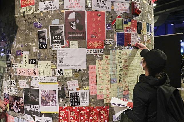 A protester adds to a wall of notes and posters related to the anti-government movement in Hong Kong, as hundreds of Hongkongers gathered near Yuen Long station on January 21 to mark the six-month anniversary of a mob attack on train passengers. Photo: Sam Tsang