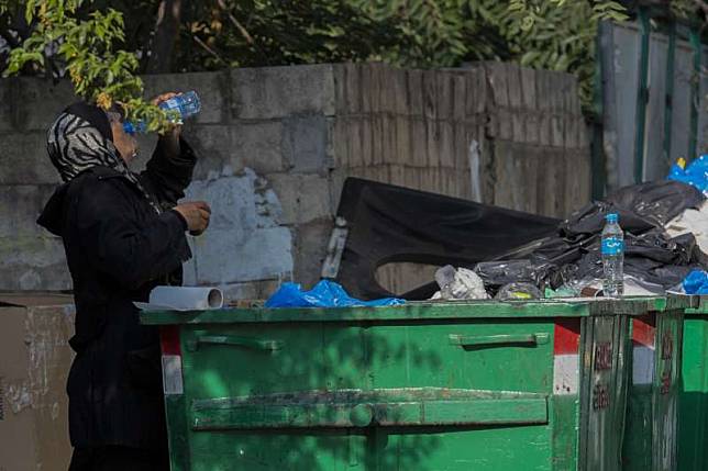 一年多來，黎巴嫩歷經經濟危機、新冠疫情與貝魯特大爆炸，經濟慘不忍睹，圖為貝魯特街友在垃圾桶撿拾飲水。（AP）