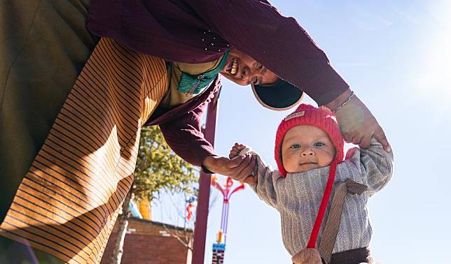 A baby toddles with help of the guardian at the new Daman Village in Jilung Town of Xigaze in southwest China's Xizang Autonomous Region, Dec. 15, 2024. The new Daman Village, about 30-kilometer away from the China-Nepal border, is the only habitat of Daman people in China. (Xinhua/Tenzin Nyida)