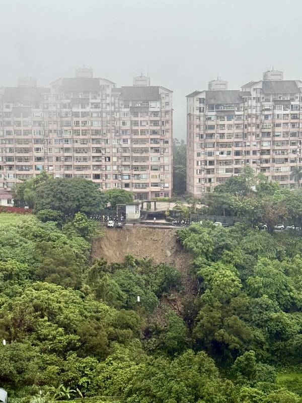 雙北地區18日午後滂沱大雨，新店區涵煙翠社區前路 段發生大片土石崩落，多輛汽車懸空在邊坡，目前暫 未傳出人員傷亡。 中央社