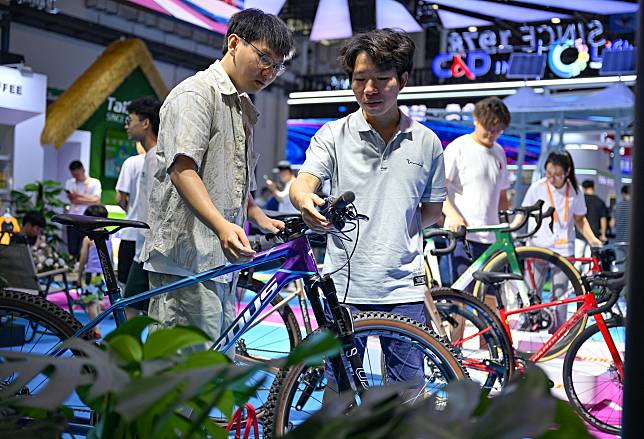 Visitors try the bicycles at the booth of Taishan Sports Industry Group Co., Ltd. during the fourth China International Consumer Products Expo in Haikou, capital city of south China's Hainan Province, April 17, 2024. (Xinhua/Guo Cheng)