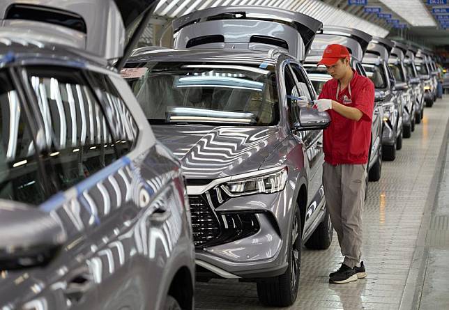 A worker checks the quality of a new energy vehicle (NEV) at the plant of BYD, China's leading NEV manufacturer, in Zhengzhou, central China's Henan Province, April 24, 2024. (Xinhua/Li Jianan)
