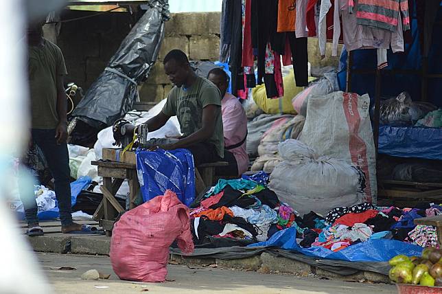 二手衣常須再修改，不能用的就成了廢棄物。非洲象牙海岸二手衣市場裡的裁縫師。圖片來源： MKwadyo