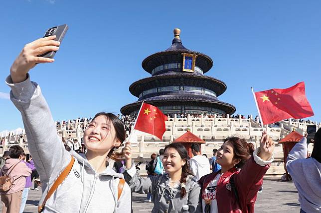 Tourists take selfies at Tiantan (Temple of Heaven) Park in Beijing, capital of China, Oct. 1, 2024. (Photo by Chen Xiaogen/Xinhua)