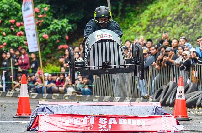 A participant drives a home-made vehicle without the engine in fun race category during the Bandung SoapBox Race 2024 in Bandung, West Java, Indonesia, Dec. 15, 2024. (Photo by Septianjar Muharam/Xinhua)