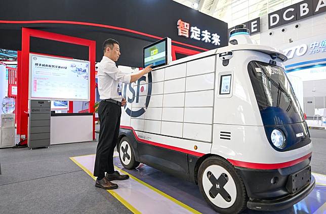 An exhibitor operates an unmanned autonomous delivery vehicle for courier service displayed at the World Intelligence Expo 2024 in north China's Tianjin, June 20, 2024. (Xinhua/Sun Fanyue)