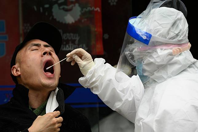 A man gets a swab test at a health clinic in Wuhan. China is now focused on containing imported cases. Photo: AFP
