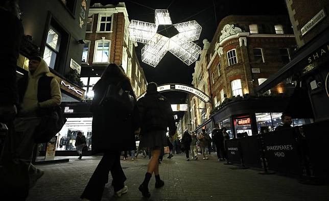 People walk on Carnaby Street decorated with lights in central London, Britain, on Nov. 27, 2024. (Xinhua/Li Ying)