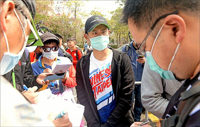 馮俊凱(中)表示，戴口罩騎車很難吸到氣。(資料照)