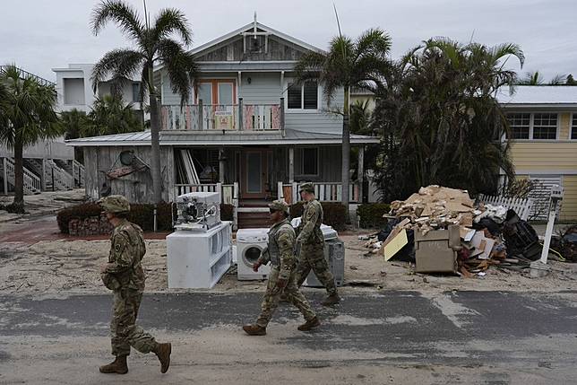 在颶風米爾頓即將登陸前夕，佛州國民兵檢查遭到颶風海倫破壞的建築物內是否還有人滯留。（美聯社）