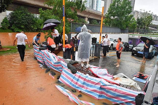 Volunteers place flood control sandbags at the entrance of an underground garage in Changsha, central China's Hunan Province, June 24, 2024. (Xinhua/Chen Zeguo)