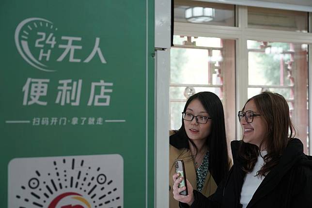 Maria ®, a Brazilian student, scans a QR code on a vending machine at the Yenching Academy of Peking University in Beijing, capital of China, April 13, 2023. (Xinhua/Ren Chao)
